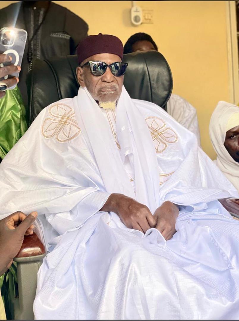 Serigne Saliou Touré, assis, vêtu de blanc